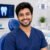 Smiling male dental patient in a modern clinic after teeth whitening treatment.